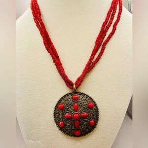 Vintage red micro bead necklace with metal circle pendant. Approx 18 inches